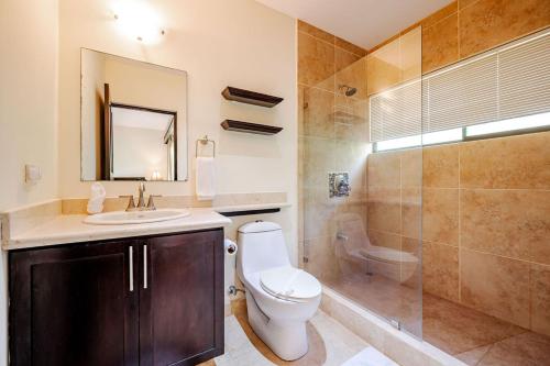 Un baño con inodoro, lavabo y ducha. en The Cove 10 2br Condo Walk To Ocotal Beach, en Ocotal