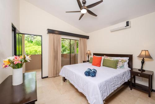 Un dormitorio con una cama con ventilador de techo. en The Cove 10 2br Condo Walk To Ocotal Beach, en Ocotal