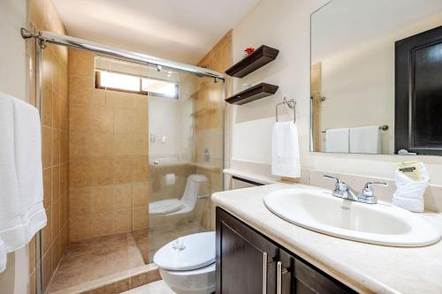 Un baño con lavabo, inodoro y ducha. en Cove #9 1br Ocotal Beach Condo 2 Guests, en Ocotal