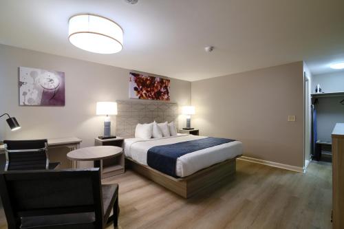 a hotel room with a bed and a desk and a chair at Knight's Inn Boston/Danvers in Danvers