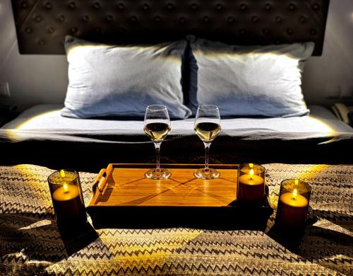 two glasses of wine on a tray on a bed with candles at Annabelle Studio in Batumi