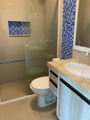a bathroom with a toilet and a sink and a shower at Doce Despertar Suítes in Brusque