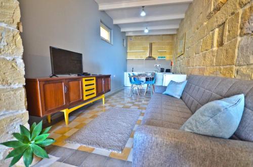a living room with a couch and a television at Eight Point Living Br6 in Birgu