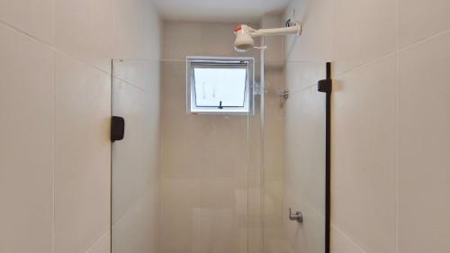 a shower with a glass door and a window at Miray Exclusive - Praia dos Carneiros in Praia dos Carneiros
