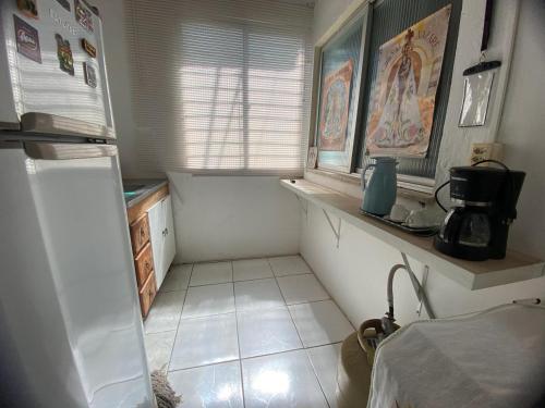 a kitchen with a refrigerator and a tiled floor at Casa para cop-30 bem localizada in Belém