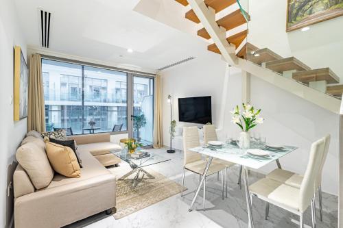 Una sala de estar con un sofá y una mesa de comedor. en Private Rooftop Jacuzzi - Duplex - Masdar City, en Abu Dabi