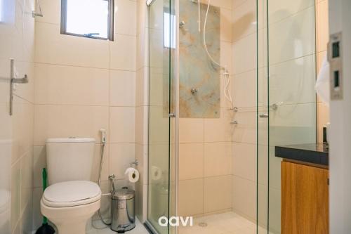 a bathroom with a toilet and a glass shower at Gaudium Apart-hotel por Quarto à Vista in João Pessoa