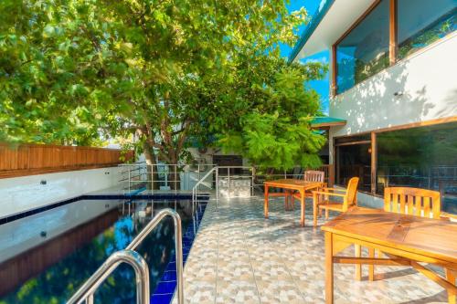 KamadhooにあるBiosphere by Hawks Hotels Kamadhoo Baa Atollのプール、テーブル、椅子付
