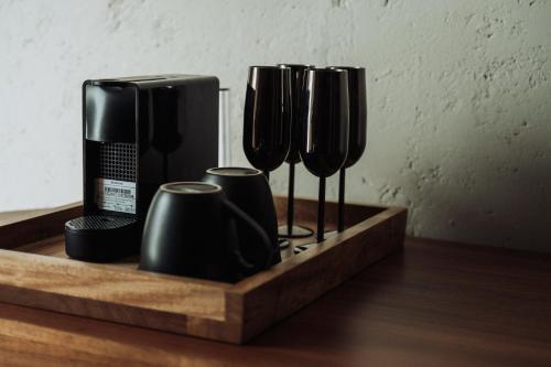 Una bandeja de madera con cuatro tazas de café sobre una mesa. en Ishak Galmoing boutique, en Tequila