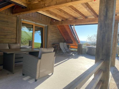 a room with a desk and chairs on a patio at Zerko Holiday Apartment Janko with a private outdoor jacuzzi for FREE in Mirna
