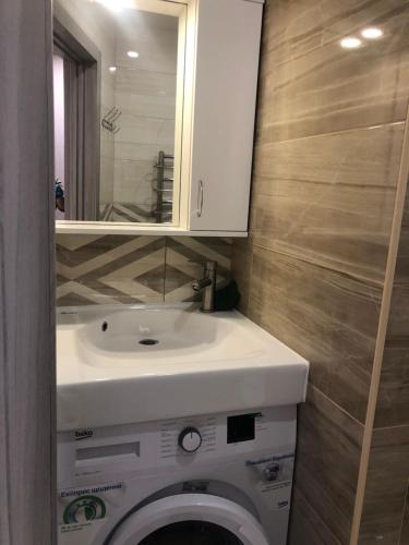 a bathroom with a white sink and a toilet at Одеська 129 in Golta