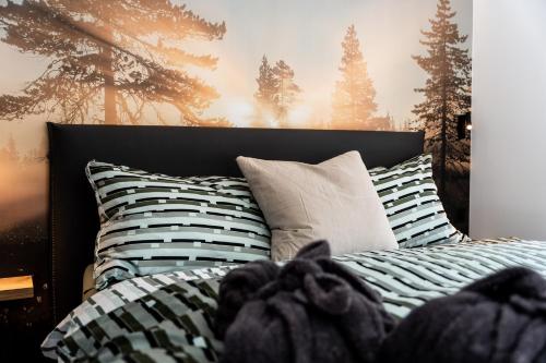 a bedroom with a bed with black and white pillows at Dalias Ferienparadies Apartment ENZIAN - Studio ALPENROSE in Saas-Almagell
