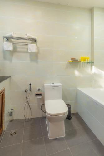 a white bathroom with a toilet and a sink at Biosphere by Hawks Hotels Kamadhoo Baa Atoll in Kamadhoo