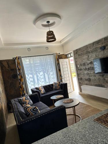 una sala de estar con un sofá y una mesa en Emburu Home Naivasha, en Munyu