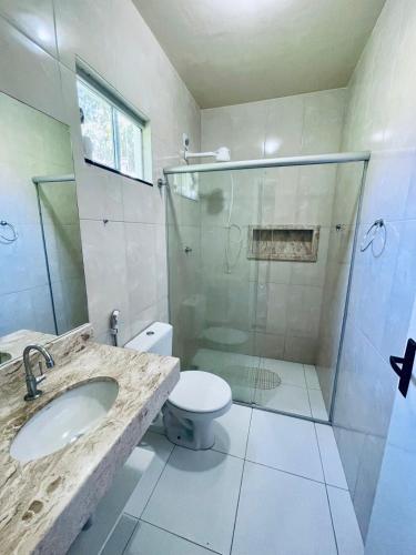 a bathroom with a shower and a toilet and a sink at Casa em bairro nobre de Prado in Prado