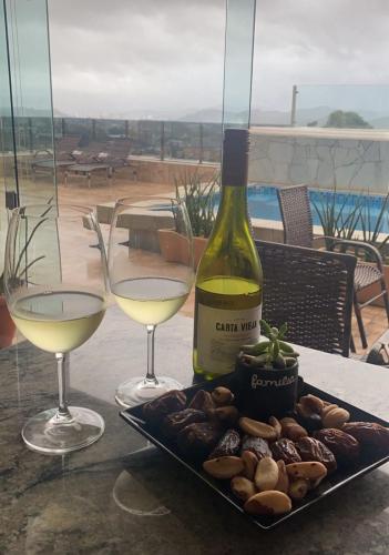 a bottle of wine and two glasses on a table at Doce Despertar Suítes in Brusque