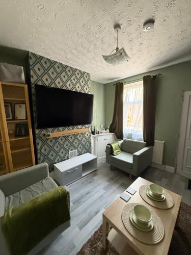 a living room with a couch and a table at Cosy Room Near Train & Hospital