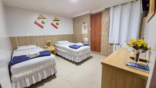 a hospital room with two beds and a sink at Hotel Ipê in Belém