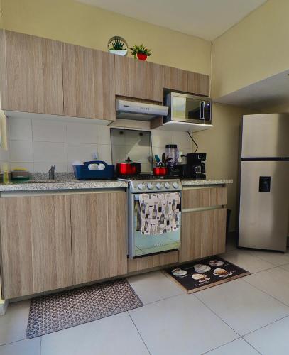 a kitchen with a stove and a refrigerator at Casa de descanso in Veracruz