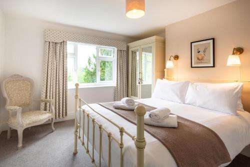 a bedroom with a bed and a chair and a window at Scarbeck House in Masham