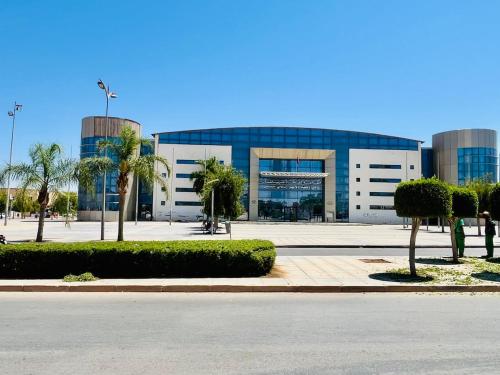 a large building with palm trees in front of it at Villa De Luxe Idéalement située à Oujda in Oujda