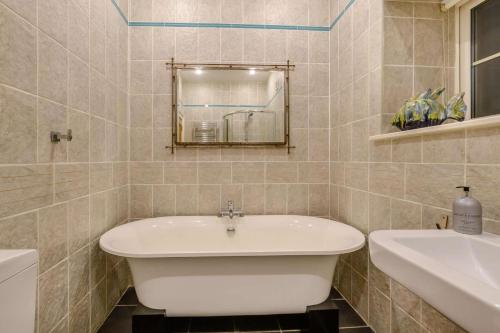 a bathroom with a white tub and a sink at Waters Edge - Warkworth in Warkworth