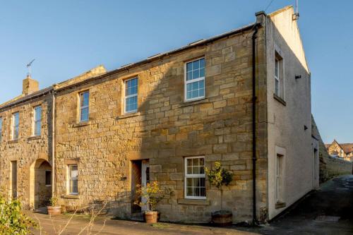 an old brick building with windows on the side at Waters Edge - Warkworth in Warkworth