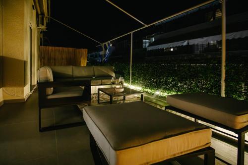 a balcony with a couch and a table at night at Luxury 2BR Apartment near the marina, Heart of Piraeus in Piraeus