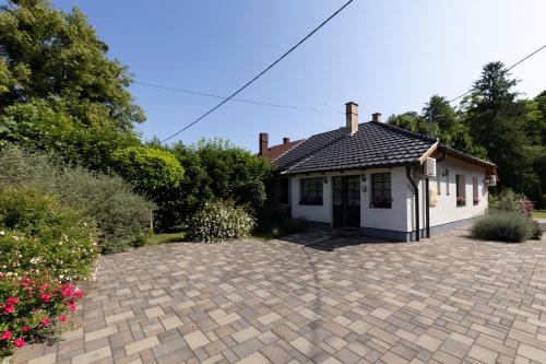 a house with a brick driveway in front of it at Morzsi Apartman in Szilvásvárad