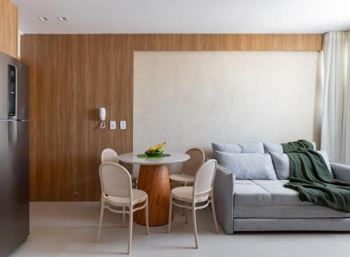 a living room with a couch and a table and chairs at Studio Moderno e Aconchegante | Pajuçara - Maceió in Maceió