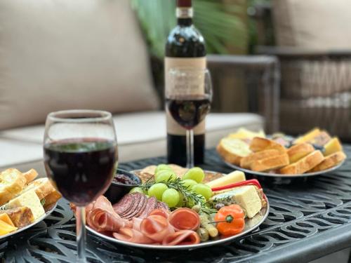 a table with two plates of food and a glass of wine at Miami River Inn by Renzzi in Miami