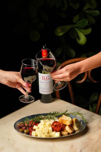 a table with a plate of food and a bottle of wine at Miami River Inn by Renzzi in Miami