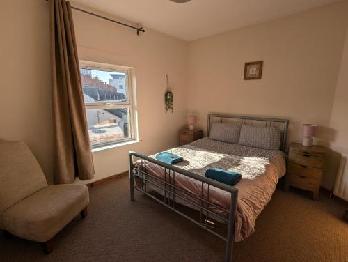 a bedroom with a bed and a chair and a window at City Centre A Apartment, 2nd Floor in Belfast