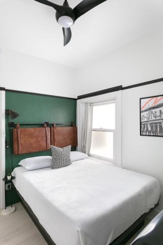 a bedroom with a large white bed with a green wall at La Ventana in San Diego