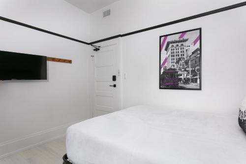 a white room with a bed and a tv at La Ventana in San Diego
