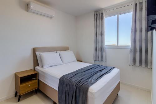 イタパリカにある2Q, Suite com TV, Shopping Boulevard, Vista para Mar, Ed Palmer, NOMDSのベッドと窓のある小さな寝室