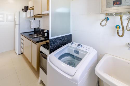 イタパリカにある2Q, Suite com TV, Shopping Boulevard, Vista para Mar, Ed Palmer, NOMDSの洗濯機付きのキッチン(シンク付)