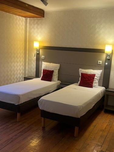 zwei Betten mit roten Kissen in einem Hotelzimmer in der Unterkunft T2 Pasteur in Nizza