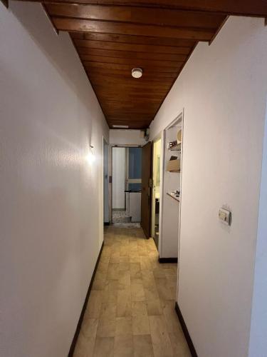 ein Flur mit einer weißen Wand und einer Holzdecke in der Unterkunft T2 Pasteur in Nizza