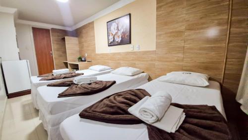 a group of three beds in a room at Hotel Ipê in Belém