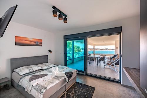ein Schlafzimmer mit einem Bett und einem Balkon in der Unterkunft Marina-Bay-Resort in Sukošan