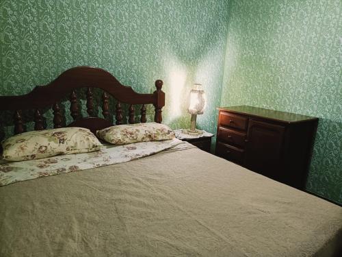 a bedroom with a bed and a dresser and a lamp at Tu Jardín Secreto Cachi in Cachí