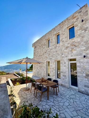 a patio with a table and an umbrella at Villa Lotos in Budva