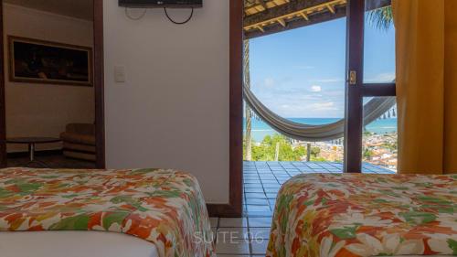 a room with two beds and a large window at Porto Seguro Eco Bahia Hotel in Porto Seguro