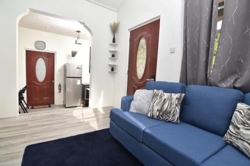 a blue couch sitting in a living room at Good Stay Apartments and Car Rentals in Gros Islet