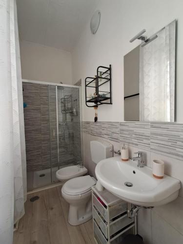 a white bathroom with a toilet and a sink at la gatta bianca in Marino
