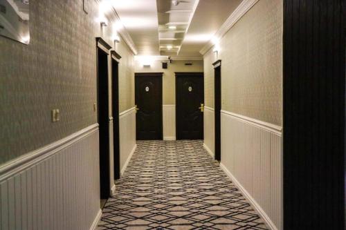a hallway with black doors and a tile floor at Z alal Hotel in Jeddah