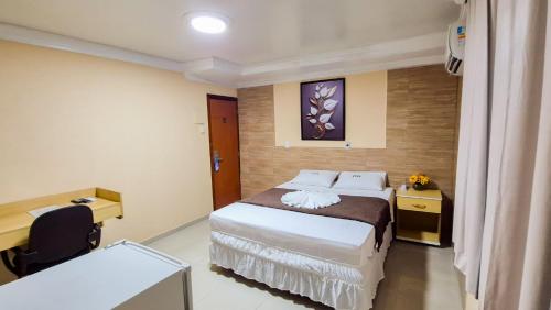 a hotel room with a bed and a desk at Hotel Ipê in Belém