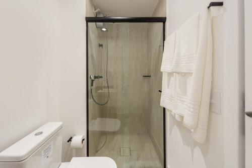a bathroom with a shower and a toilet and towels at House of Charlie Paraiso in Sao Paulo