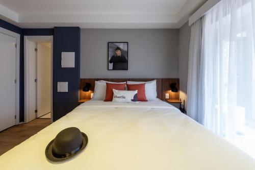 a bedroom with a large bed with a hat on it at House of Charlie Paraiso in Sao Paulo